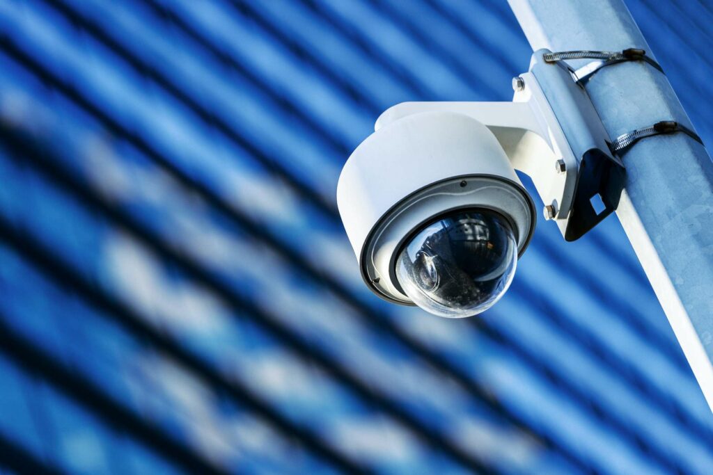 A security camera against a blue background.