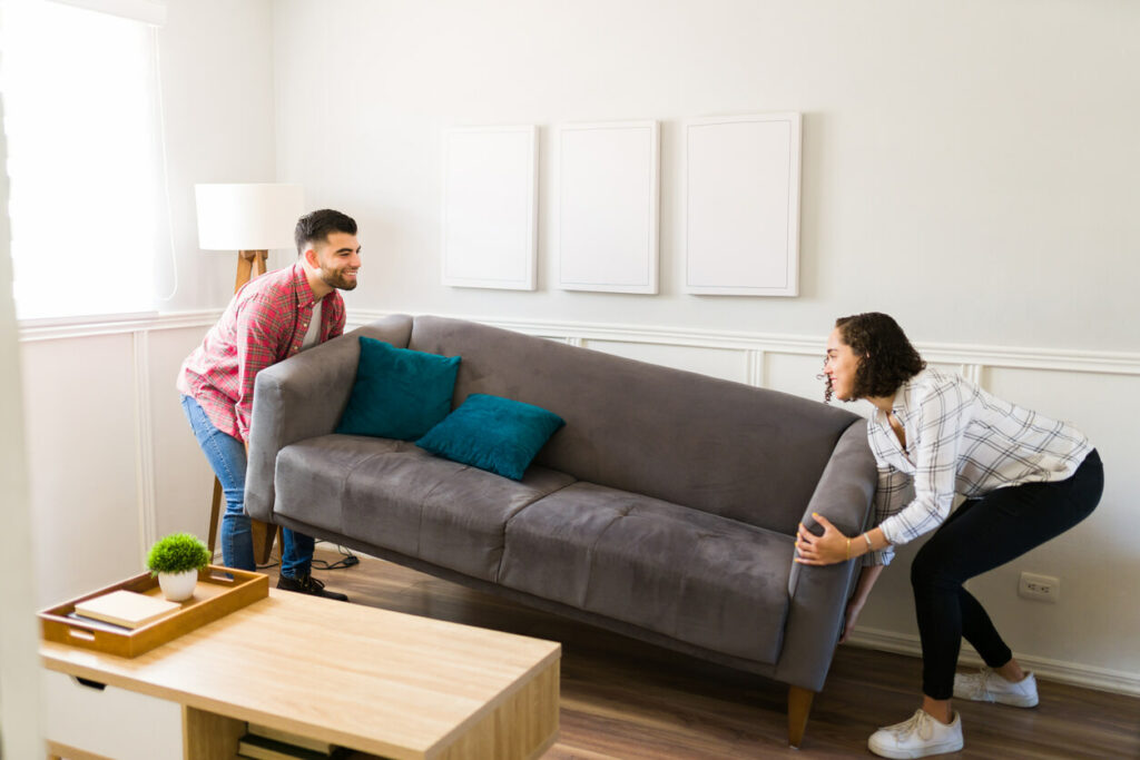 A man and woman moving a couch into place