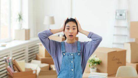 Woman concerned with boxes taking up space behind her.