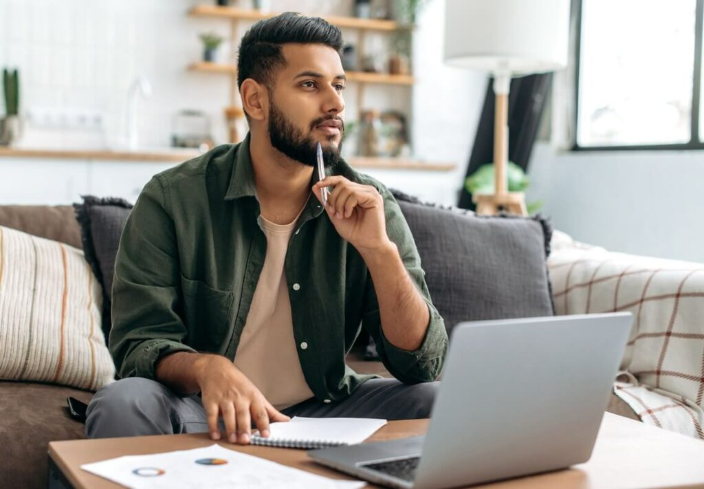 Man working on his computer and considering his options.