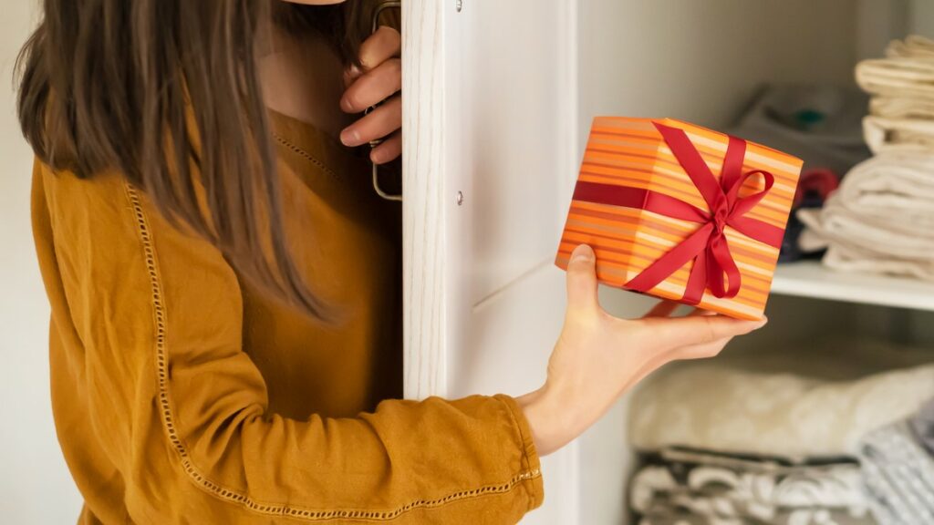 A woman hides a gift in a closet where her family may find it.