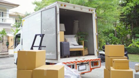 A moving truck surrounded by boxes ready to be loaded.