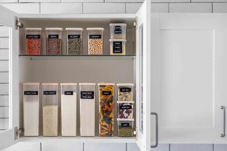 Well-organized kitchen cabinet with containers and labels