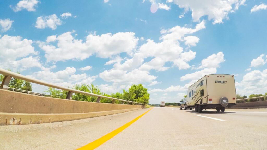 A truck pulling a trailer drives east on a Kentucky highway during a cross-country road trip.